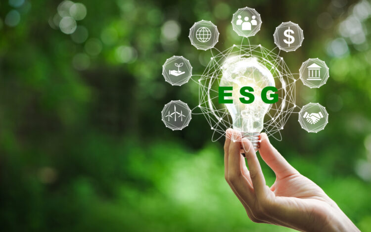 Hand holding light bulb with ESG icon concept for environmental, social, and governance in sustainable and ethical business on the Network connection on a green background.